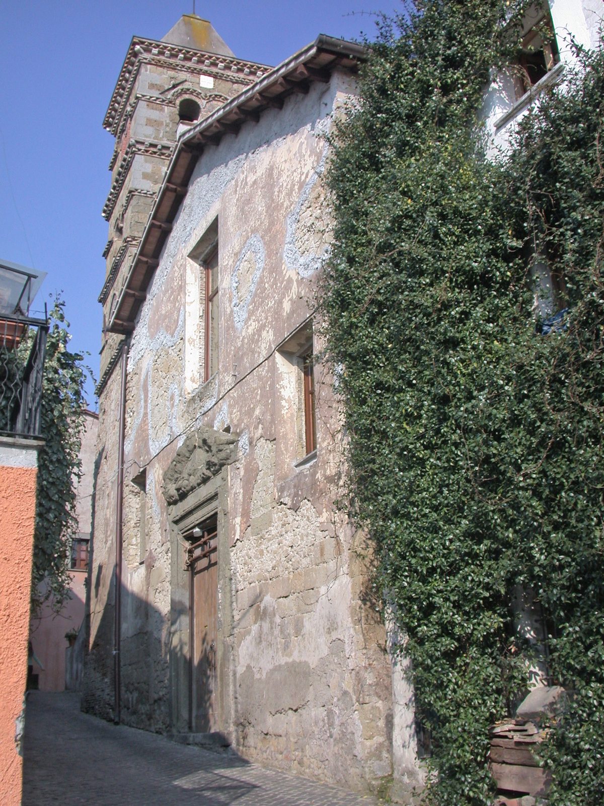 Facciata della chiesa di San Michele Arcangelo a Formello, in un vicolo ricoperto di edera